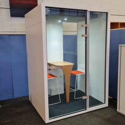 Telefonbox mit Glastüren und Glasrückwand und einem kleinen Tisch