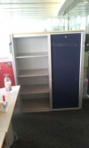 gebrauchter Schiebetürenschrank mit einer blauen Türe und 4 Ordnerhöhen