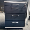 Chefbüro Schreibtisch in Esche schwarz mit Metallsichtblende und passendem Sideboard dahinter