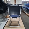 blauer, gebrauchter Freischwinger mit schwarzen Armlehnen