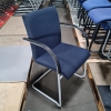 gebrauchter Freischwinger mit dunkelblau gemusterten Polster und Armlehnen
